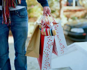Man holding gift bags --- Image by © Ocean/Corbis